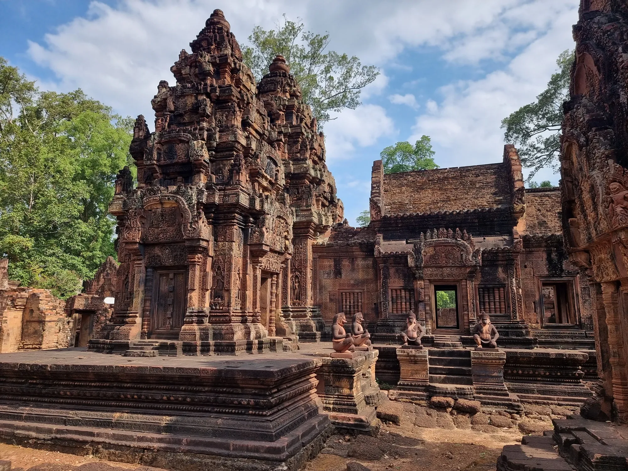 Les tours sculptées de Banteay Srei, gardées par des statues accroupies, au centre de l'enceinte