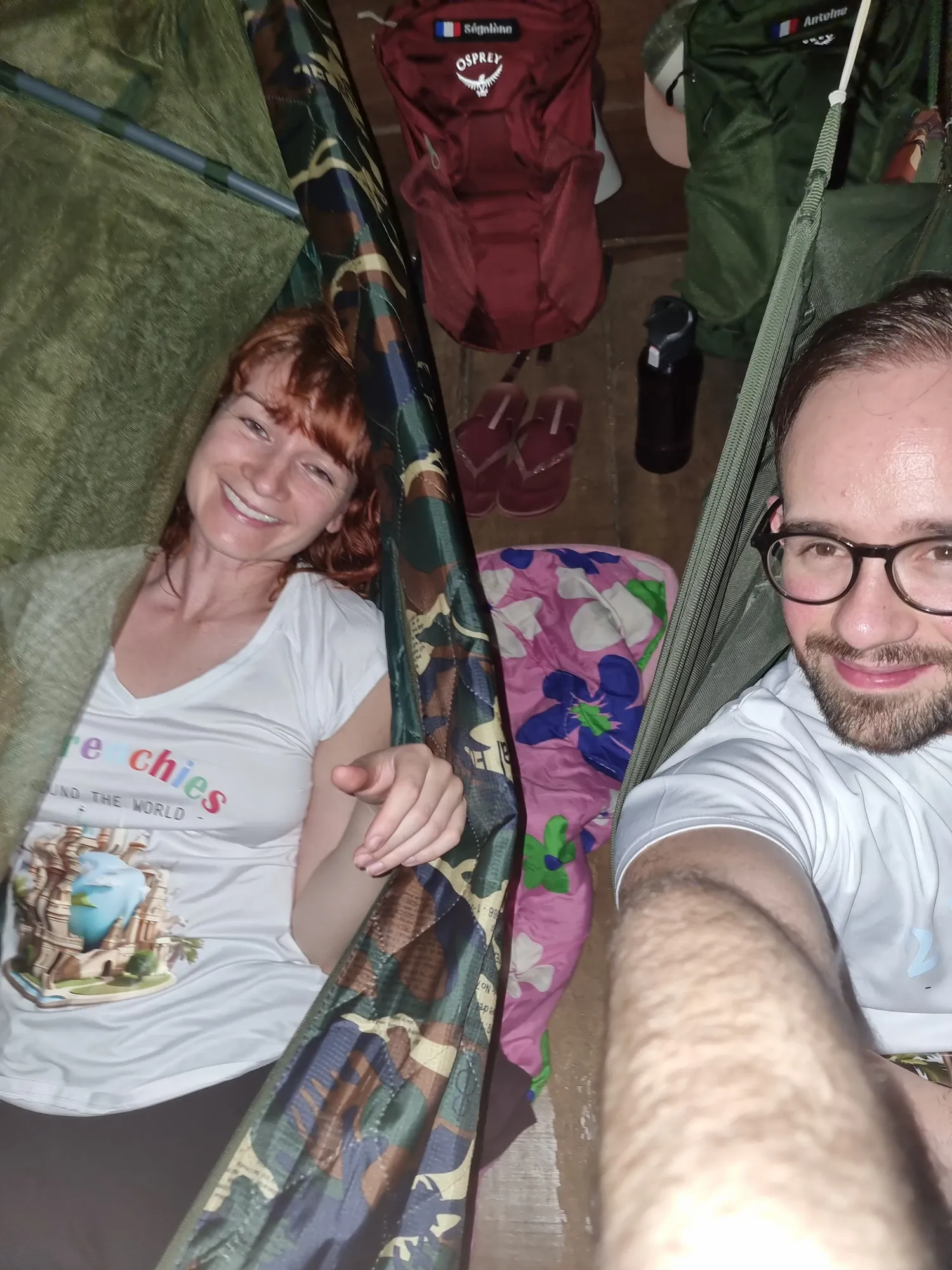 Ségolène et Antoine allongés chacun dans un hamac sous moustiquaire, au Jungle Lodge, avec leurs sacs à dos posés au sol derrière eux