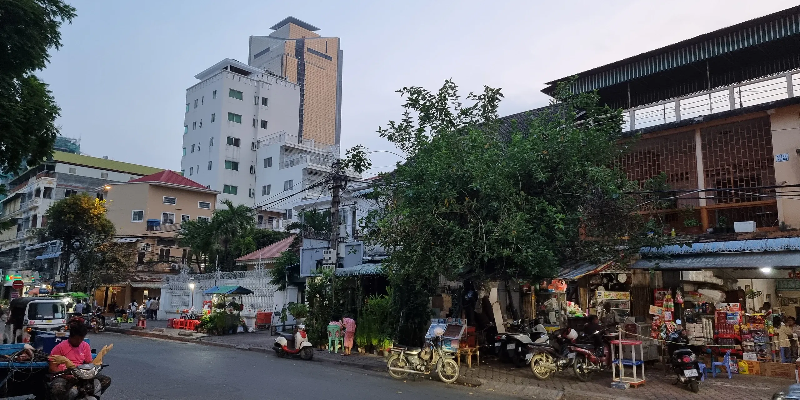 Une rue de Phnom Penh à la tombée du jour, avec ses scooters garés devant les échoppes, le soir de notre arrivée en mars 2025