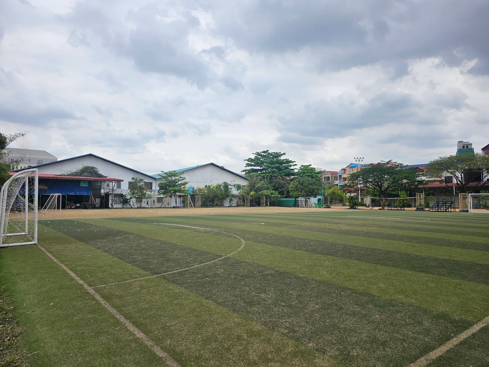 Le terrain de football de l'ONG Pour un Sourire d'Enfant, avec ses buts et les bâtiments de l'école au fond