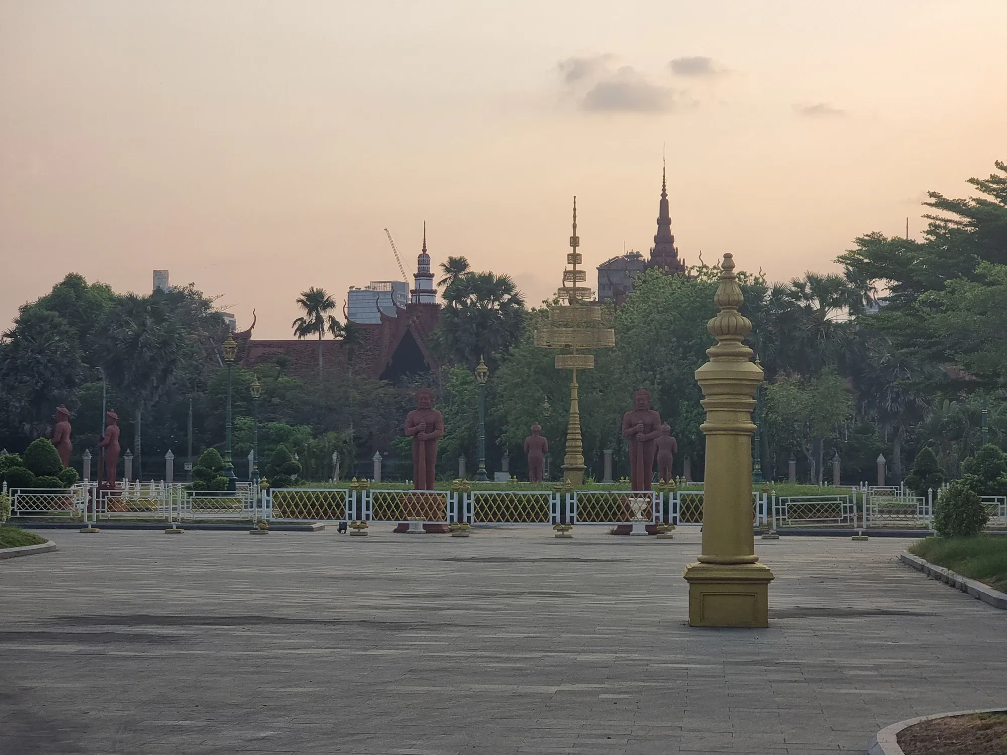 Des statues rouges dans le parc devant le Musée national de Phnom Penh, à la tombée du jour
